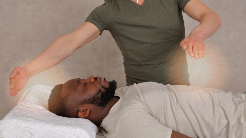 man receiving energy healing with healing practitioner